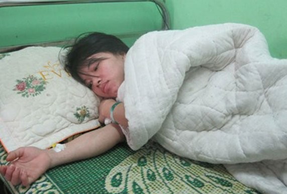 Chị Lê Thị Phương đang nằm điều trị tại bệnh viện sau khi bị viên chủ quản A Vương đổ keo 502 dính tay.